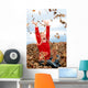 happy seven year old girl playing in pile of leave Wall Mural