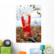 happy seven year old girl playing in pile of leave Wall Mural