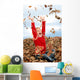 happy seven year old girl playing in pile of leave Wall Mural