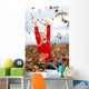 happy seven year old girl playing in pile of leave Wall Mural