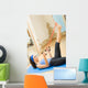 Young happy woman exercising with expander at home Wall Mural