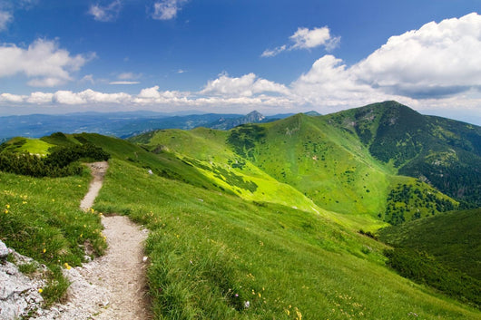 Mountain-ridge and blue sky with white clouds Wall Mural