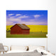 A Red Farm Building Against A Canola Field Wall Mural