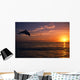 Silhouette Of Bottlenose Dolphin Leaping Over Ocean At Sunset Wall Mural