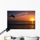 Silhouette Of Bottlenose Dolphin Leaping Over Ocean At Sunset Wall Mural