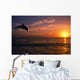 Silhouette Of Bottlenose Dolphin Leaping Over Ocean At Sunset Wall Mural