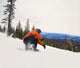 Snowboarder Crouching Down Low As He Descends Snow Hill Wall Mural