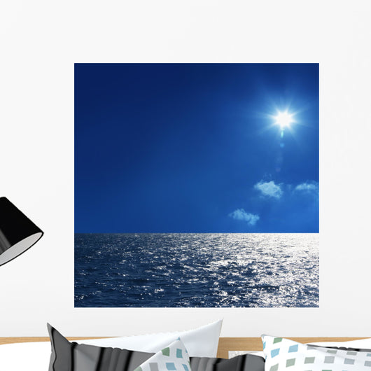 a background image of an open sea and blue sky Wall Mural