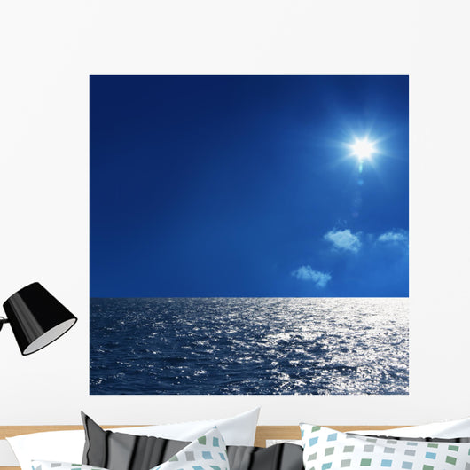 a background image of an open sea and blue sky Wall Mural