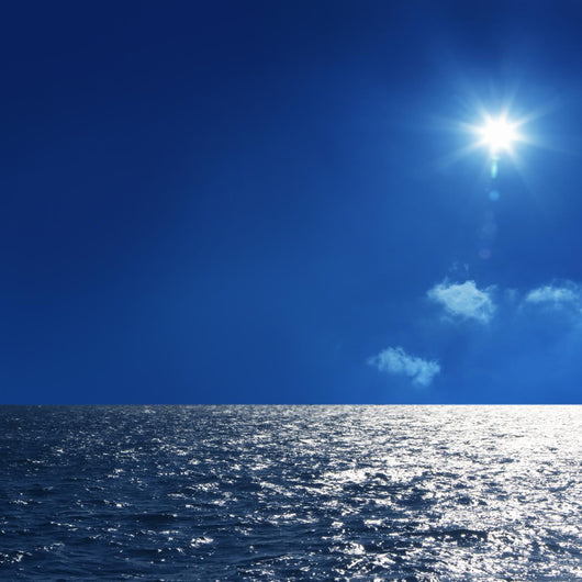 a background image of an open sea and blue sky Wall Mural