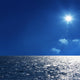 a background image of an open sea and blue sky Wall Mural