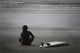 Surfer Sitting On Beach, Cox Bay Near Tofino, British Columbia, Canada Wall Mural