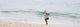 Person Walking On The Beach With A Fishing Net Wall Mural