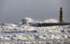 Waves Crashing Against A Pier With A Lighthouse Wall Mural