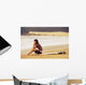 Young Woman Sitting On Her Surf Board On The Beach Wall Mural