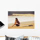 Young Woman Sitting On Her Surf Board On The Beach Wall Mural