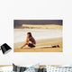 Young Woman Sitting On Her Surf Board On The Beach Wall Mural