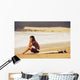 Young Woman Sitting On Her Surf Board On The Beach Wall Mural