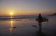 Silhouetted Surfer On Sandy Beach At Sunset Wall Mural