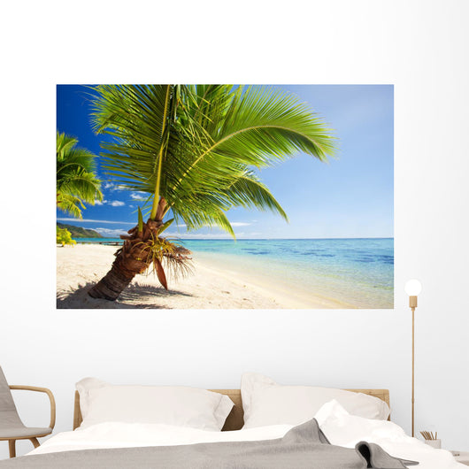 Small palm tree hanging over stunning lagoon Wall Mural