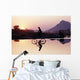 Bicyclist Crossing Shallow River At Sunset With Women Wall Mural