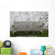 A Wooden Bench With Peeling Paint Against A White Wall Wall Mural