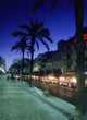 Palm Tree Lined Promenade With People Eating In Restaurants At Dusk Wall Mural