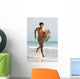 A Man Running Along Valdevaqueros Beach Carrying A Surf Board Wall Mural