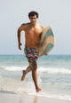 A Man Running Along Valdevaqueros Beach Carrying A Surf Board Wall Mural