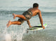 A Man Entering The Water On A Surf Board Off Valdevaqueros Beach Wall Mural