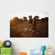 A Man Riding His Bike Through Tall Grass At Sunset Wall Mural