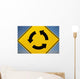 A Yellow Sign Showing Three Arrows Going In A Circle Wall Mural
