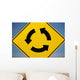 A Yellow Sign Showing Three Arrows Going In A Circle Wall Mural