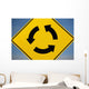 A Yellow Sign Showing Three Arrows Going In A Circle Wall Mural