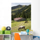 Cattle Grazing On An Alpine Meadow With A Barn And Mountains Wall Mural