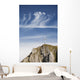 Mountain Peak With A Cross On Top Against A Blue Sky With Clouds Wall Mural