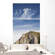 Mountain Peak With A Cross On Top Against A Blue Sky With Clouds Wall Mural