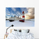Boats Sitting On A Frozen Surface With A Lighthouse And Building Wall Mural