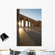 A row of archways against a blue sky and sunlight shining through Wall Mural