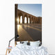 A row of archways against a blue sky and sunlight shining through Wall Mural