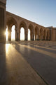 A row of archways against a blue sky and sunlight shining through Wall Mural