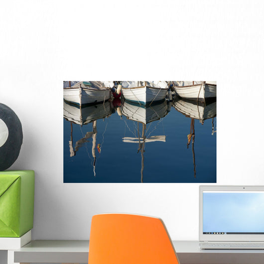 Boats mooring in a harbour with the mirror image in the tranquil water Wall Mural