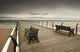 A Wooden Pier With Benches Looking Out Over The Beach And Water Wall Mural