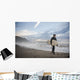 A Young Man Carries His Surfboard Down The Beach Wall Mural