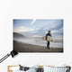 A Young Man Carries His Surfboard Down The Beach Wall Mural