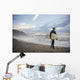 A Young Man Carries His Surfboard Down The Beach Wall Mural