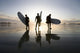 Silhouette Of Three Surfers Carrying Surfboards Wall Mural