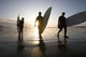 Silhouette Of Three Surfers Carrying Surfboards Wall Mural
