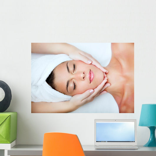 Beautiful young woman receiving facial massage. Wall Mural
