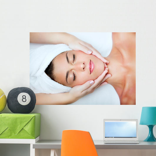 Beautiful young woman receiving facial massage. Wall Mural